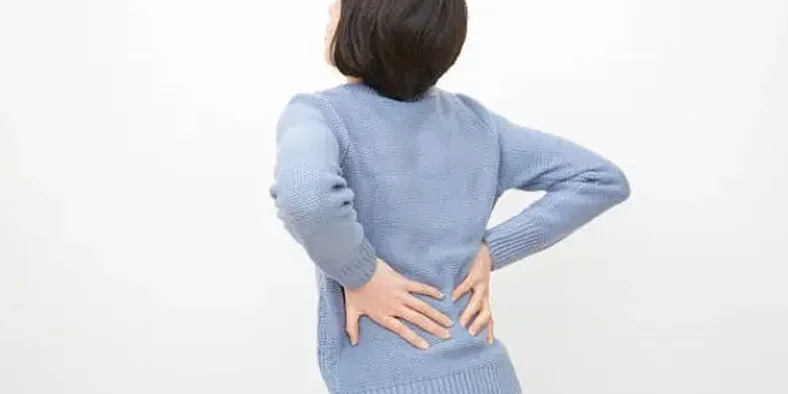 Wanita sedang memegang punggung yang sakit