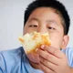 anak obesitas memegang roti