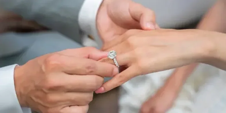 Pria menyematkan cincin lamaran pada jari wanita