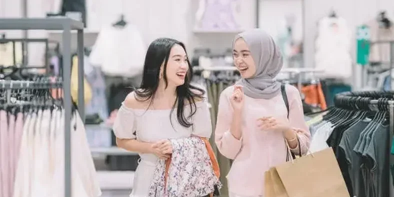 Dua orang wanita sedang berbelanja pakaian