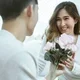 suami memberikan bunga kepada istri