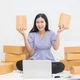 Wanita bisnis online memegang paket pesanan